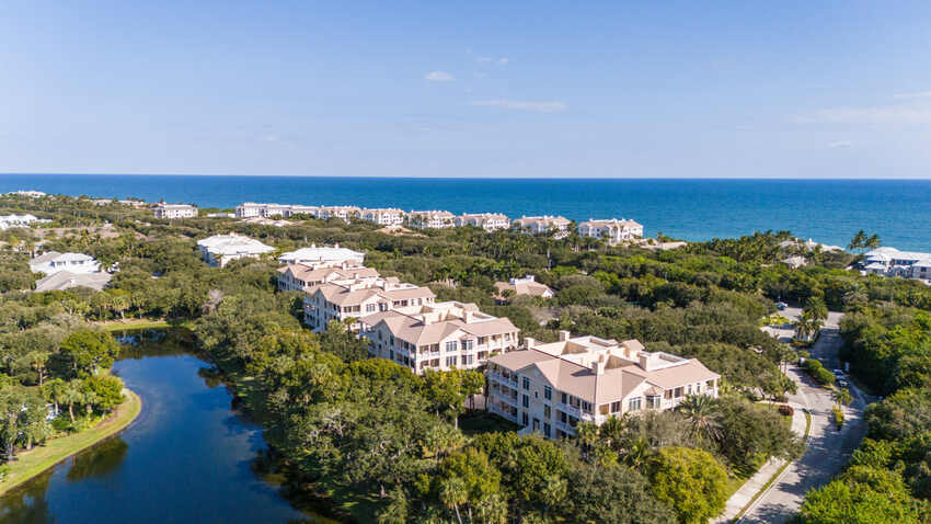 Aerial view of oceanfront residences at a Vero Beach beach and tennis club community with the Atlantic Ocean beyond