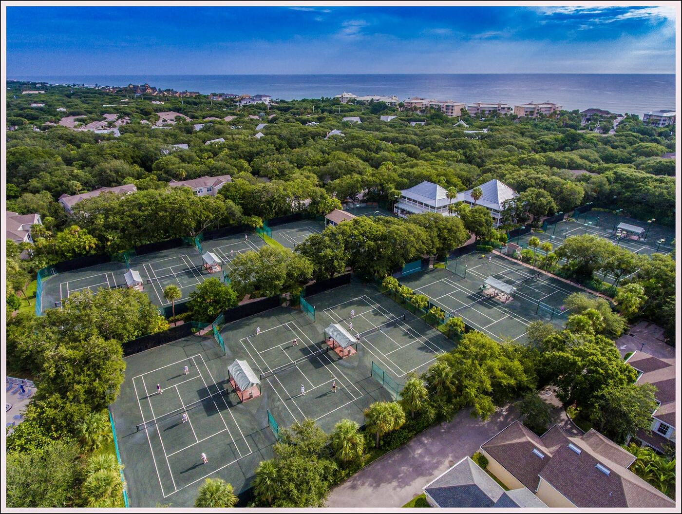 Aerial view of Grand Harbor's Har-Tru tennis courts with the Atlantic Ocean beyond